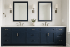 Elegant bathroom with navy blue vanity cabinets refinished through a cabinet painting service, featuring dual sinks, marble countertop, and modern fixtures.